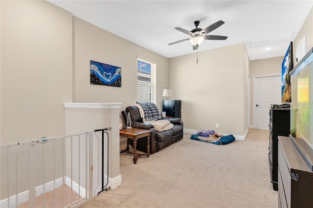 living area with ceiling fan and light colored carpet