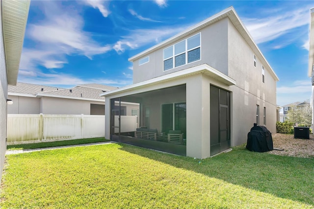 rear view of house with central AC, a lawn, and a sunroom