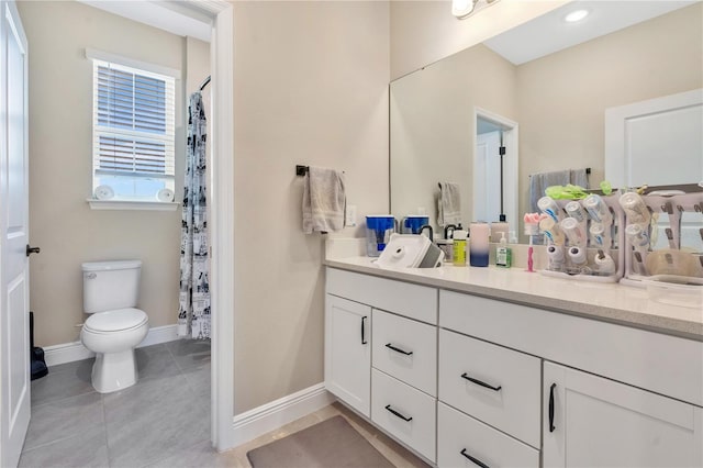 bathroom with tile patterned flooring, vanity, and toilet