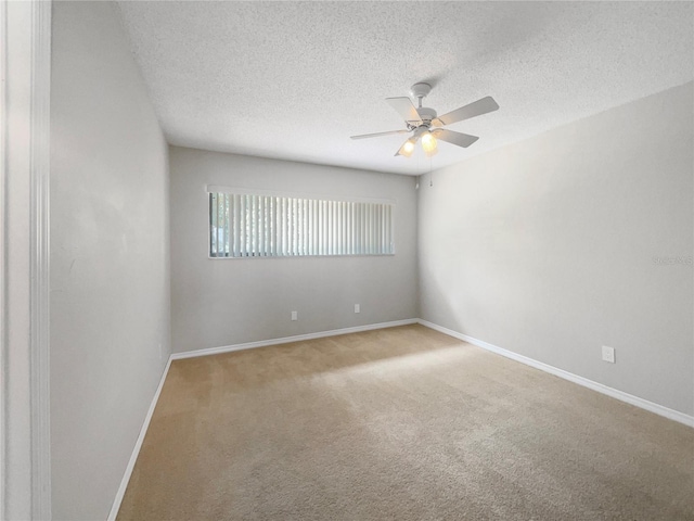 spare room with light carpet, ceiling fan, and a textured ceiling