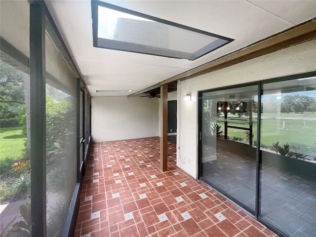 unfurnished sunroom with ceiling fan