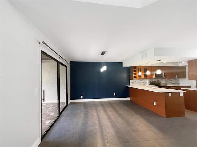 kitchen with kitchen peninsula, decorative backsplash, a kitchen bar, appliances with stainless steel finishes, and decorative light fixtures