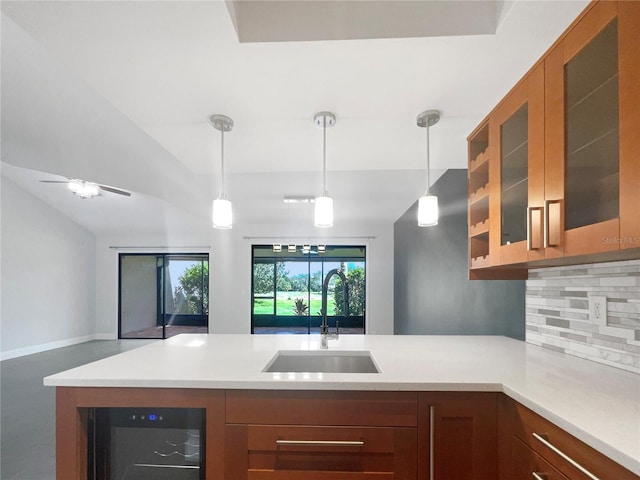 kitchen with sink, beverage cooler, tasteful backsplash, pendant lighting, and lofted ceiling