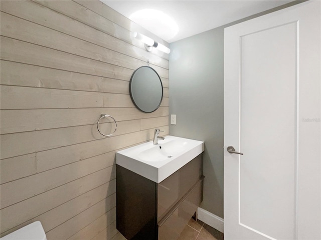 bathroom featuring tile patterned floors, vanity, and wood walls