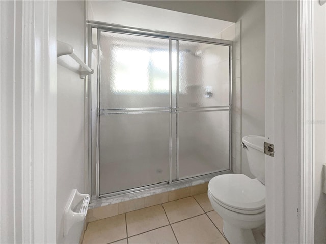 bathroom with tile patterned flooring, toilet, and walk in shower