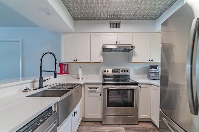 kitchen with white cabinets, appliances with stainless steel finishes, and sink