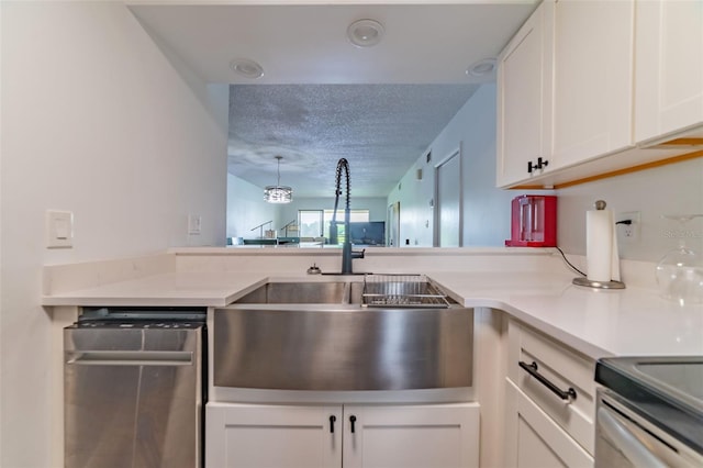 kitchen with a textured ceiling, dishwasher, kitchen peninsula, sink, and white cabinetry