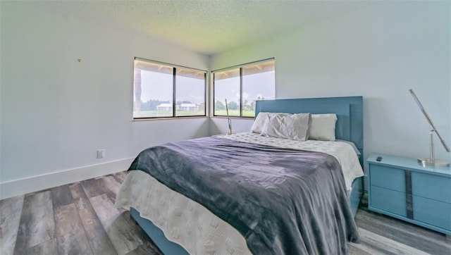 bedroom with a textured ceiling and hardwood / wood-style floors