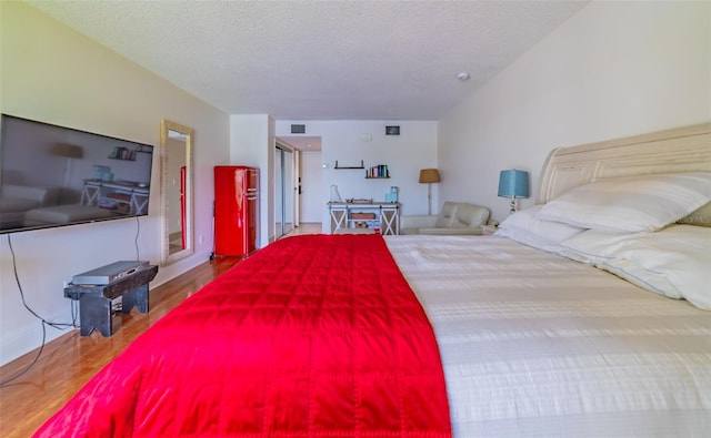 bedroom featuring a textured ceiling and wood-type flooring