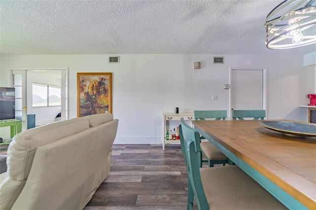 dining space featuring a textured ceiling and dark hardwood / wood-style floors