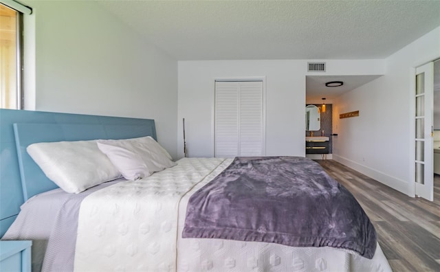 bedroom featuring a textured ceiling, a closet, and wood-type flooring