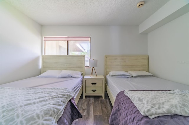 bedroom with a textured ceiling and dark wood-type flooring