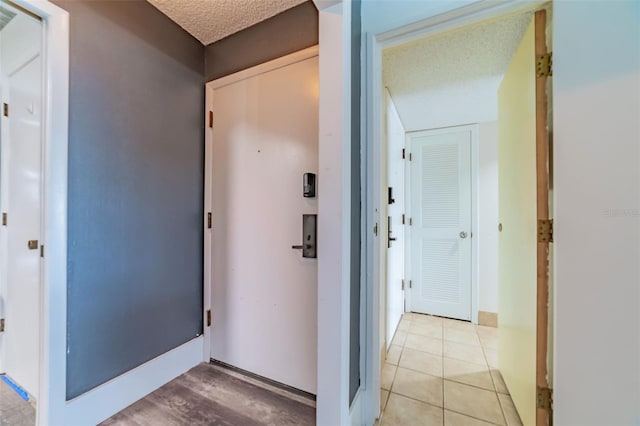 corridor featuring a textured ceiling and light wood-type flooring