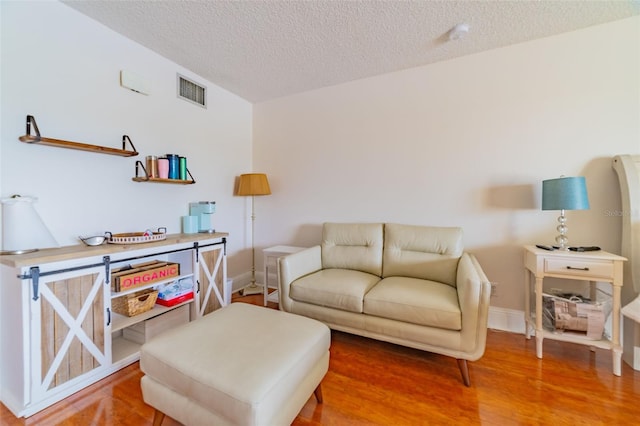 living room featuring a textured ceiling and hardwood / wood-style floors