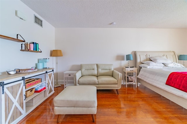 bedroom featuring a textured ceiling and wood-type flooring