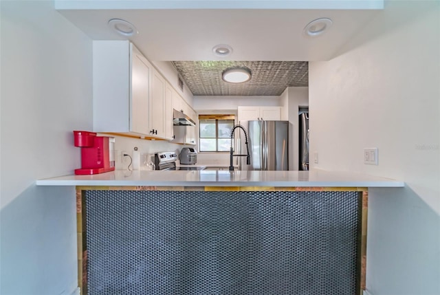 kitchen featuring kitchen peninsula, stainless steel fridge, stove, and white cabinets