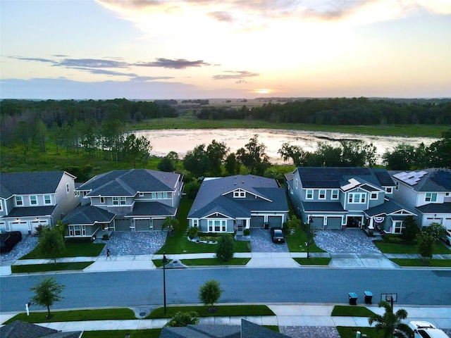 aerial view at dusk featuring a water view