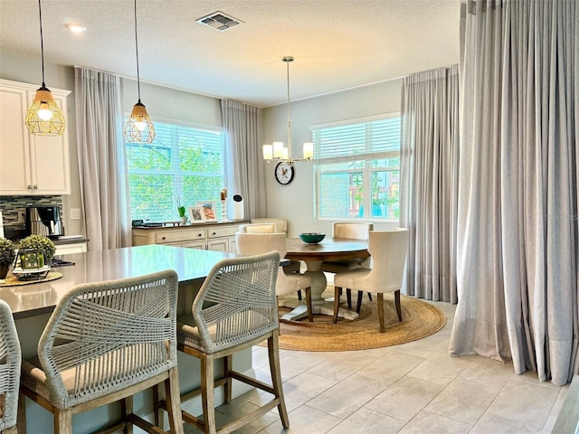 interior space with a textured ceiling and a chandelier