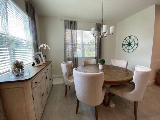 dining area with light tile patterned flooring and an inviting chandelier