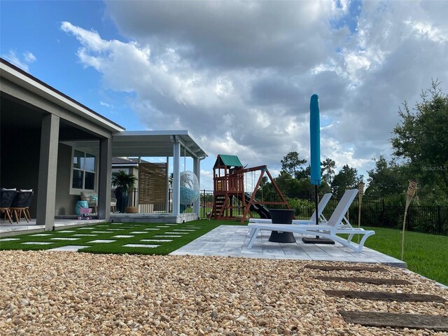 view of yard featuring a playground and a patio