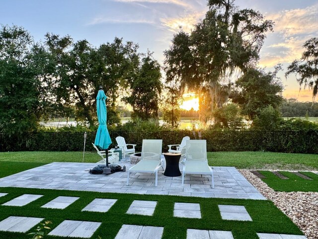 yard at dusk featuring a patio area