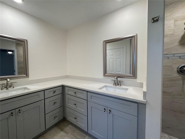 bathroom featuring tiled shower and vanity