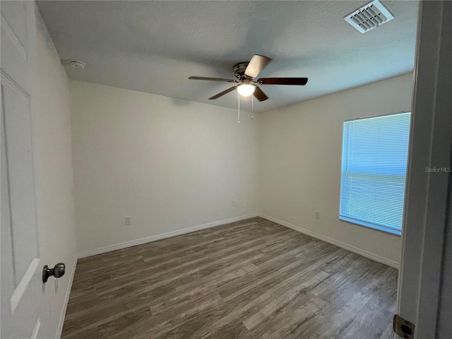 spare room featuring hardwood / wood-style floors, ceiling fan, and plenty of natural light