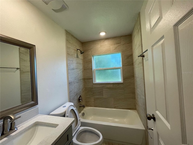 full bathroom with tiled shower / bath combo, vanity, toilet, and a textured ceiling