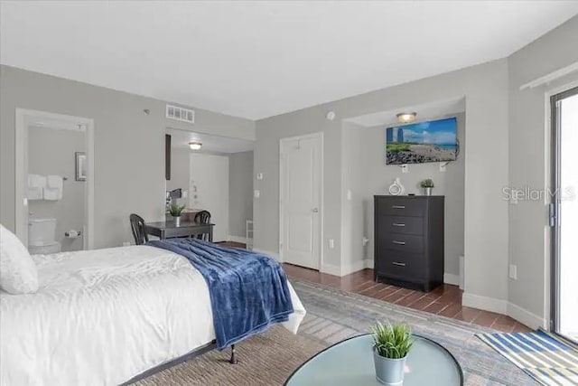 bedroom with dark hardwood / wood-style floors and connected bathroom