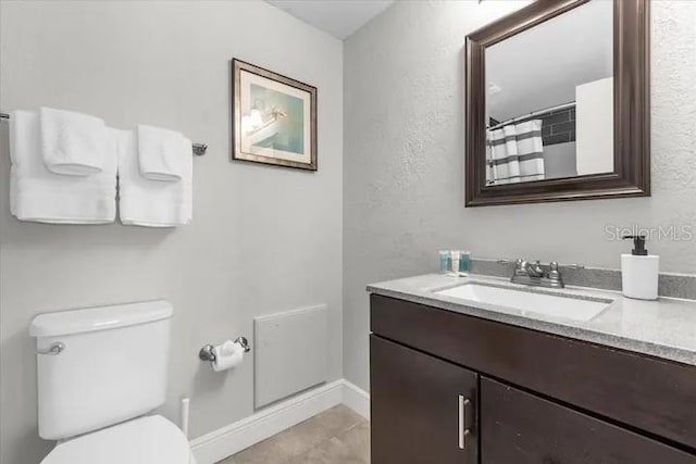 bathroom featuring tile patterned floors, vanity, and toilet