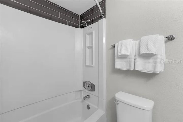 bathroom featuring bathtub / shower combination and toilet