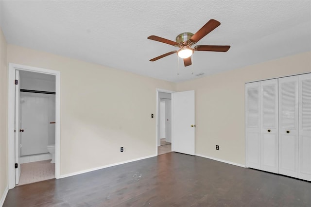 unfurnished bedroom with ensuite bathroom, a closet, ceiling fan, and a textured ceiling