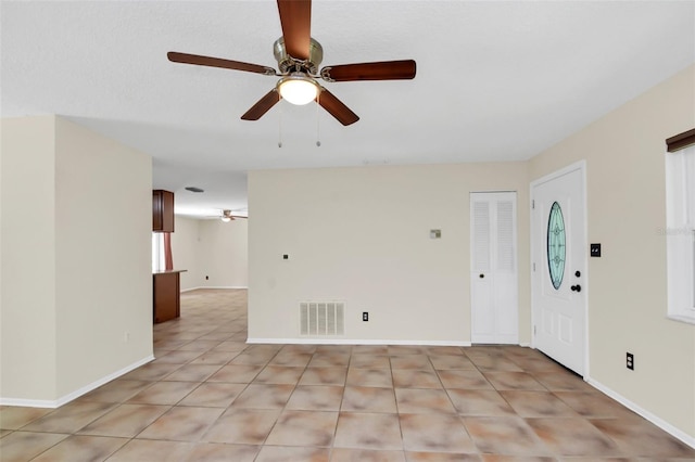 interior space with ceiling fan and light tile patterned floors