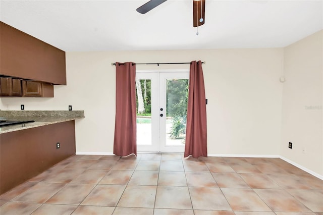 kitchen featuring light stone countertops, french doors, light tile patterned floors, and ceiling fan