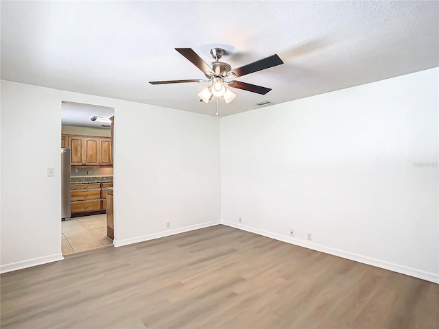 empty room featuring ceiling fan and light wood-type flooring