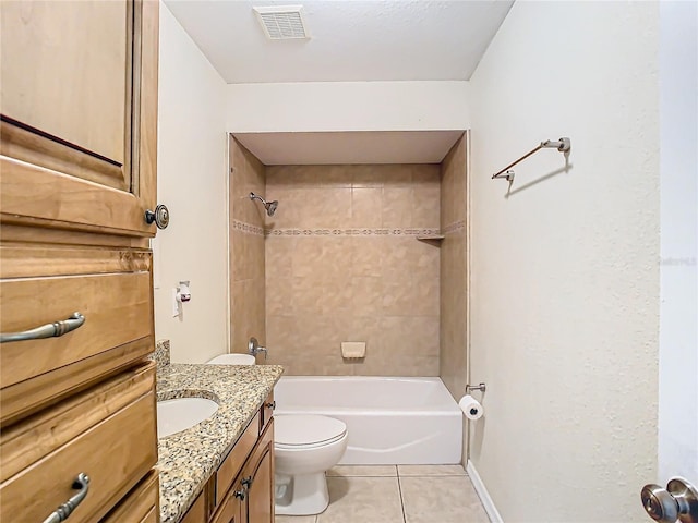 full bathroom featuring tile patterned flooring, vanity, tiled shower / bath combo, and toilet