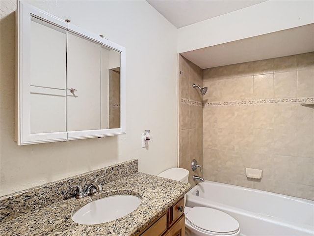 full bathroom with vanity, tiled shower / bath, and toilet