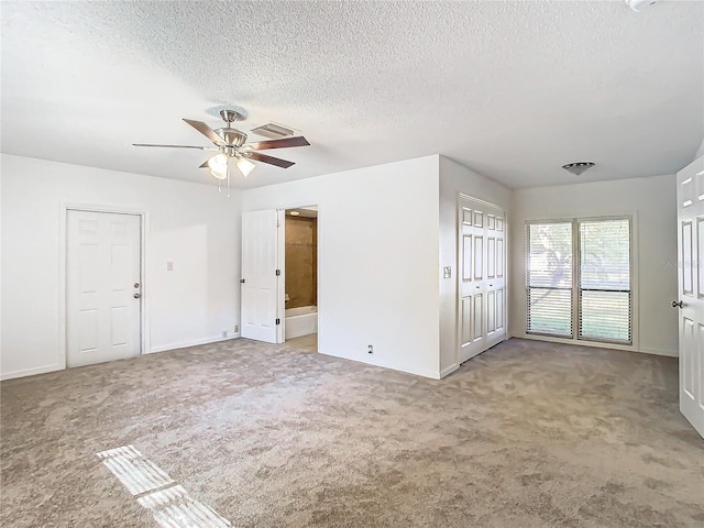 carpeted spare room with ceiling fan and a textured ceiling