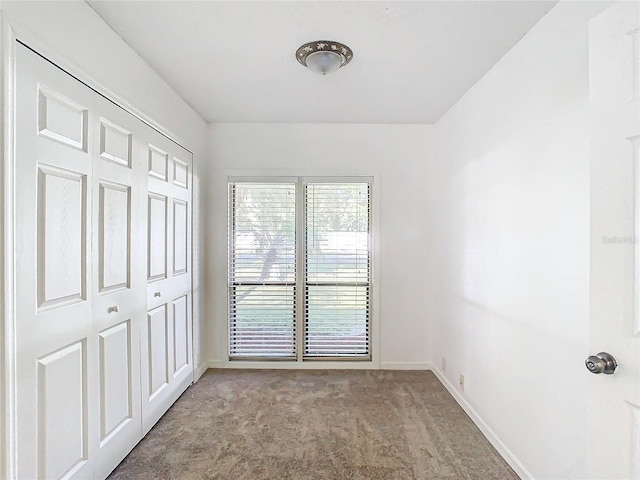 unfurnished bedroom featuring light colored carpet and a closet