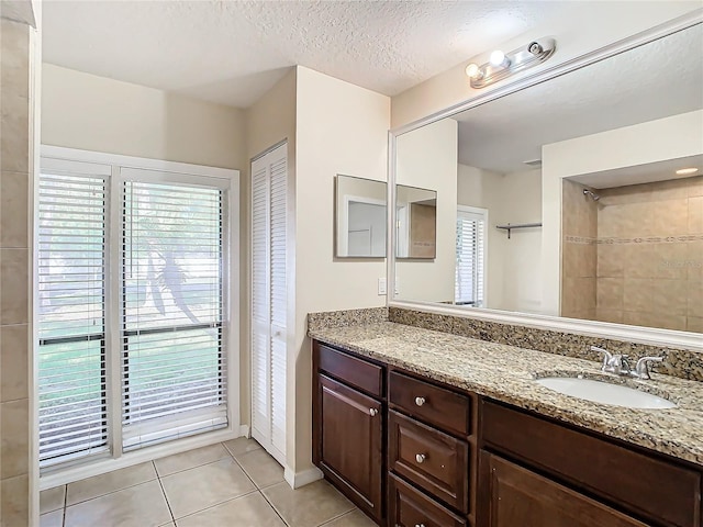 bathroom featuring tile patterned flooring, vanity, and a textured ceiling