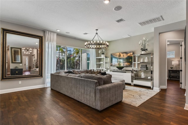 living area with a textured ceiling, wood finished floors, and visible vents