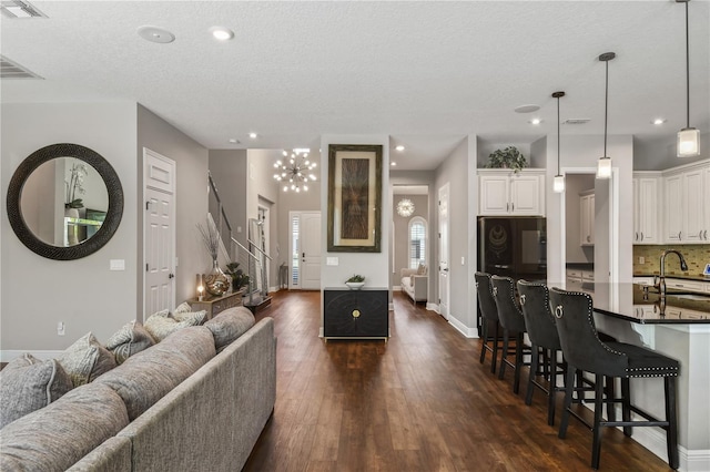 living area featuring dark wood-type flooring, recessed lighting, visible vents, and baseboards