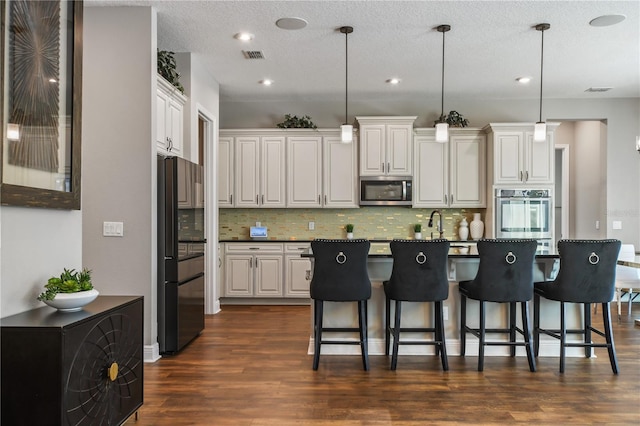 kitchen with white cabinetry, appliances with stainless steel finishes, decorative backsplash, and dark wood-style flooring