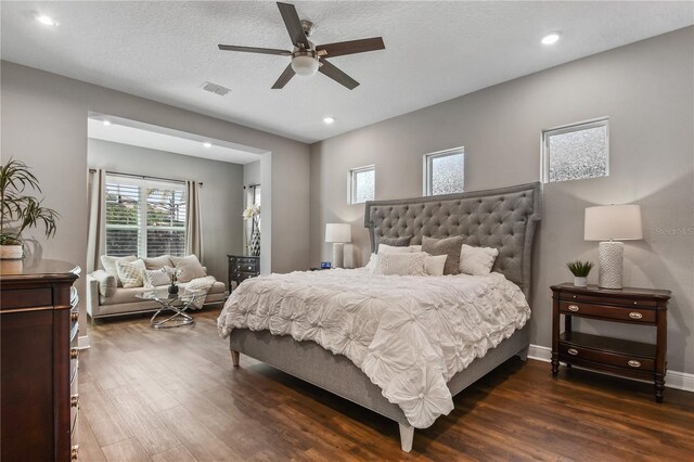 bedroom featuring recessed lighting, visible vents, dark wood-type flooring, a textured ceiling, and baseboards