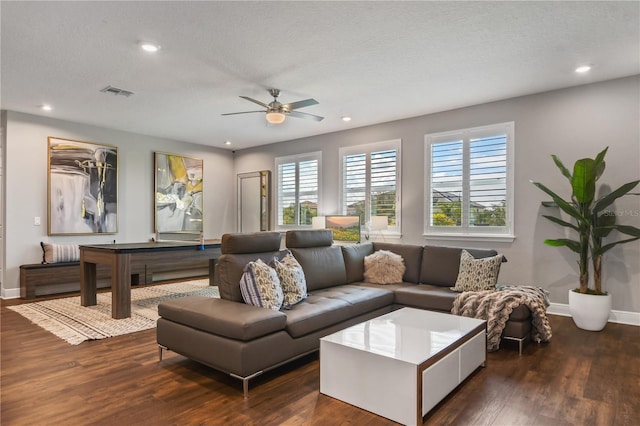 living area with baseboards, dark wood-style flooring, a textured ceiling, and recessed lighting