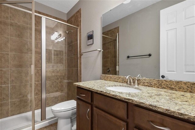 full bathroom with toilet, a stall shower, tile patterned flooring, and vanity