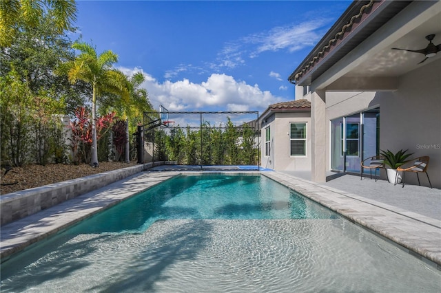 outdoor pool with a ceiling fan and a patio area