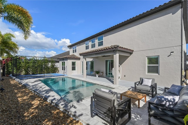 back of house with an outdoor pool, a patio, a tiled roof, outdoor lounge area, and stucco siding