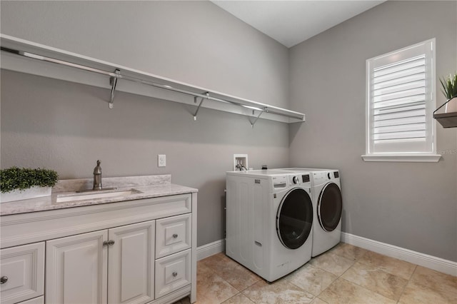 clothes washing area featuring a sink, cabinet space, baseboards, and washer and dryer