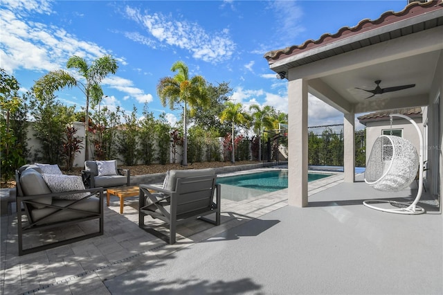 view of pool featuring an outdoor hangout area, a patio area, a fenced backyard, and a ceiling fan